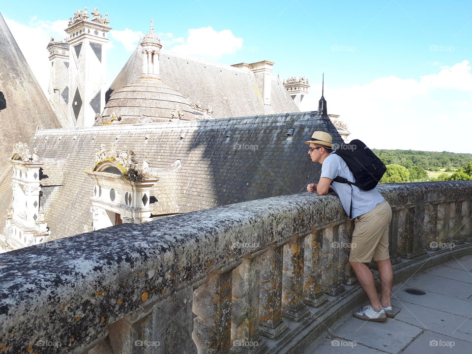 Man at the castle balcony with backpack