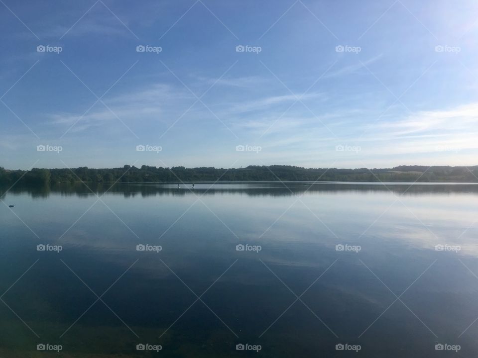 View across Stewartby Lake in Bedfordshire, with light cloud 
