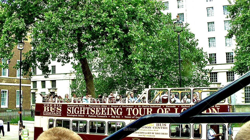 Double-decker tour bus full of site-seeing tourists in London 