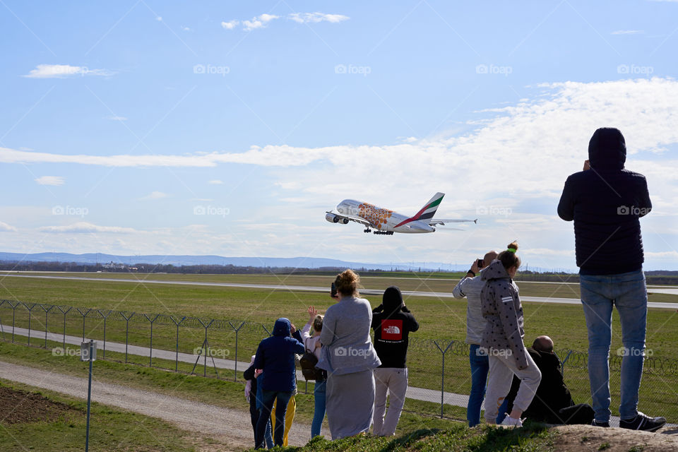 People watching the take off a plane.( Emirates Airline flight) 