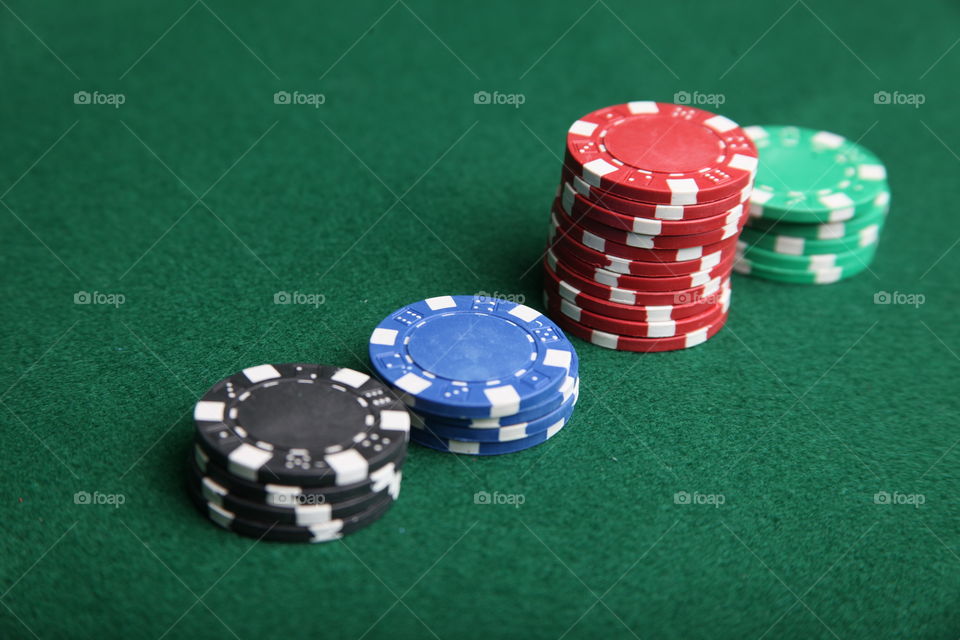 Poker Chips. This is a photograph of Poker Chips on a green felt table.