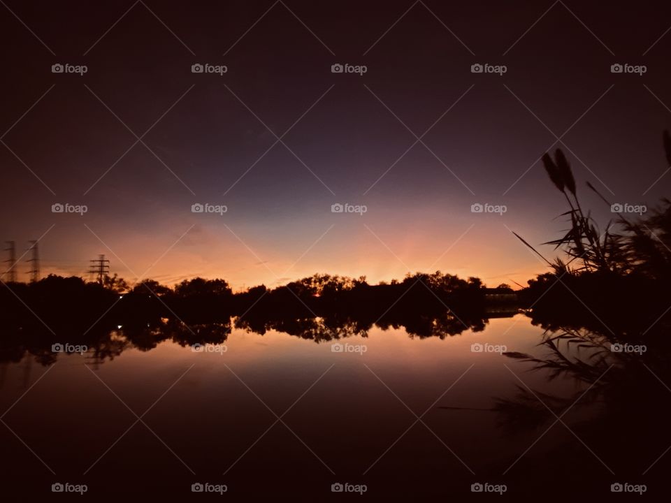Wow sunset has faded through Twilight. Gorgeous backlit Colours oranges, pinks represent the Beauty of the Evening which now is falling to Night. Reflections and Mirrored Images are Captivating the scene v
