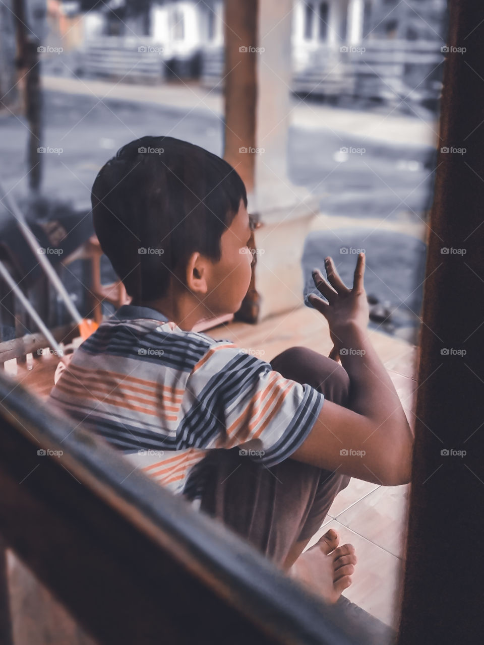 Bengkulu, Indonesia - july 1th, 2021 - a small child counting by hand and photographed from behind a window