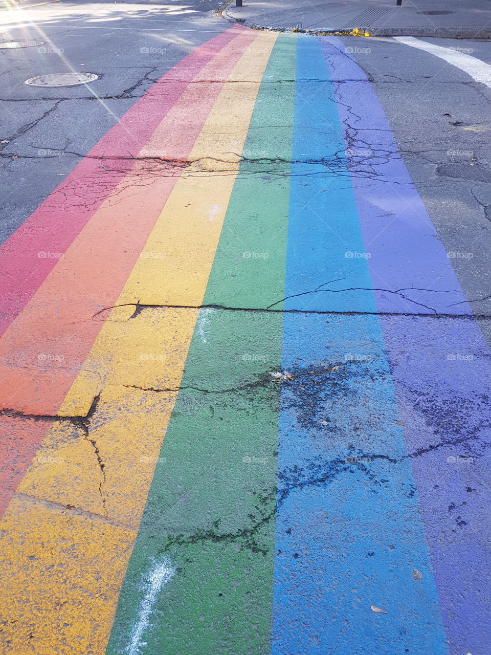 A pedestrian crossing with a rainbow instead of the traditional white stripes. Montréal. Canada.