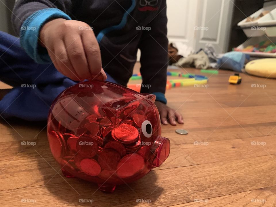 Child inserting money into piggy bank. Savings young quarters change