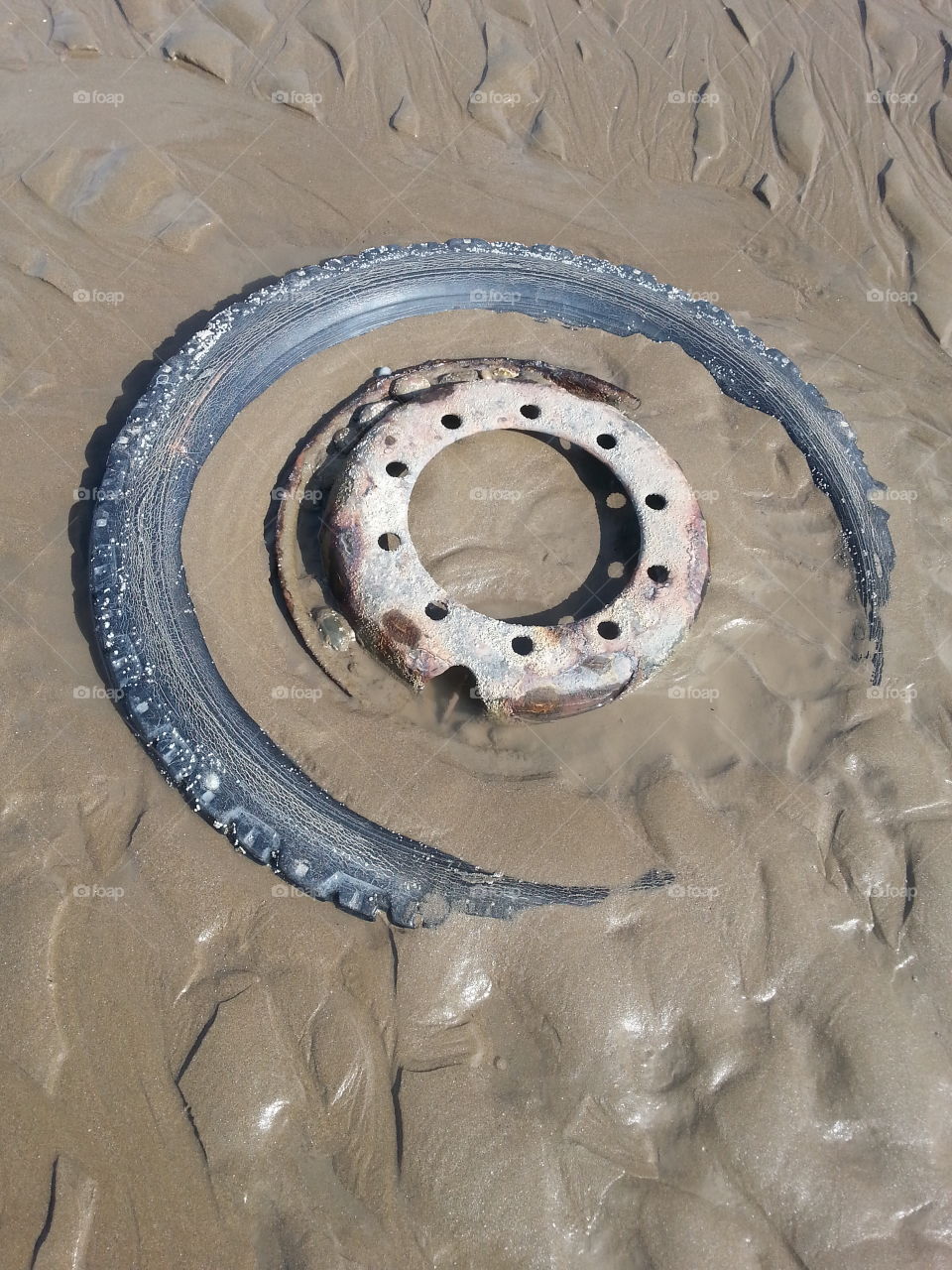 Tyre in the sand. Came across this washed up on my local beach in South Wales UK