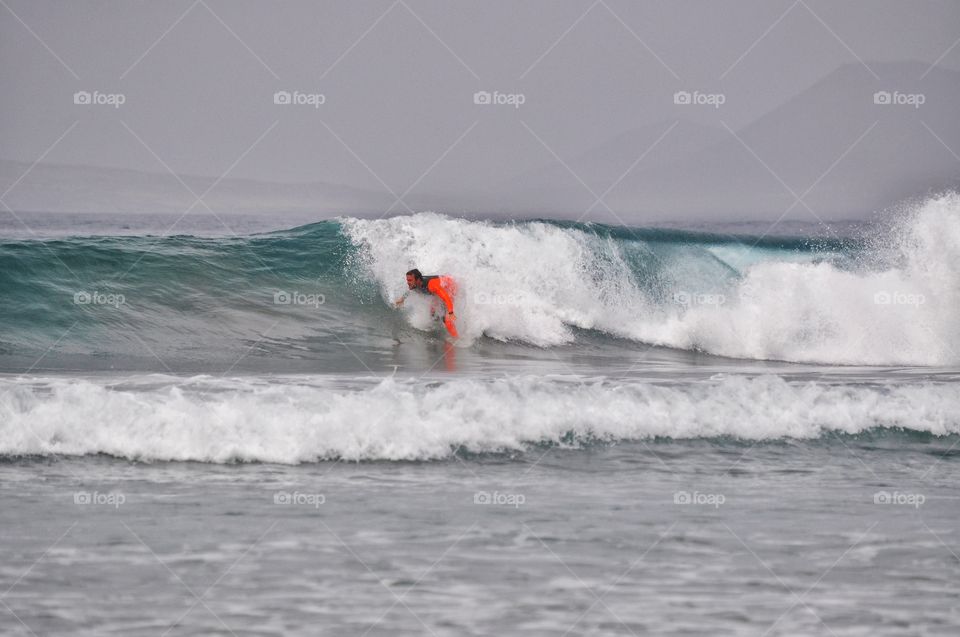 surfing on famara beach on lanzarote canary island in Spain