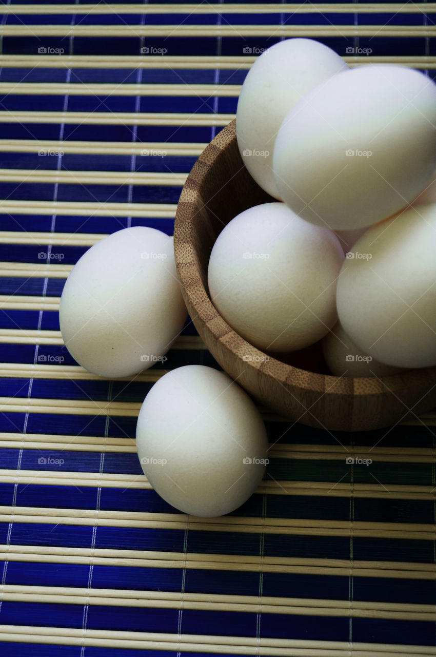 close up of group of eggs in natural light with striped background