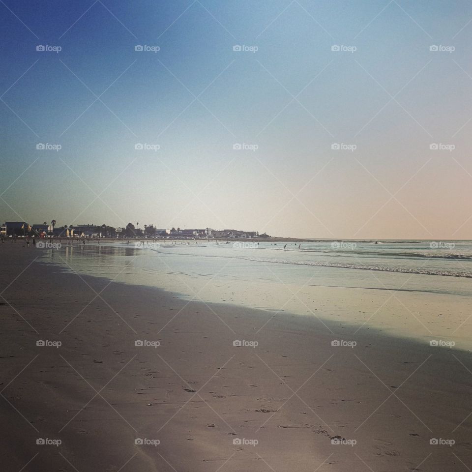 A walk on a beautiful beach in the late afternoon. Calm waves gently in