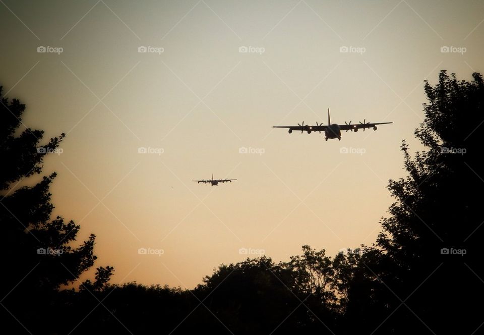 Airplane flying in sky at sunset