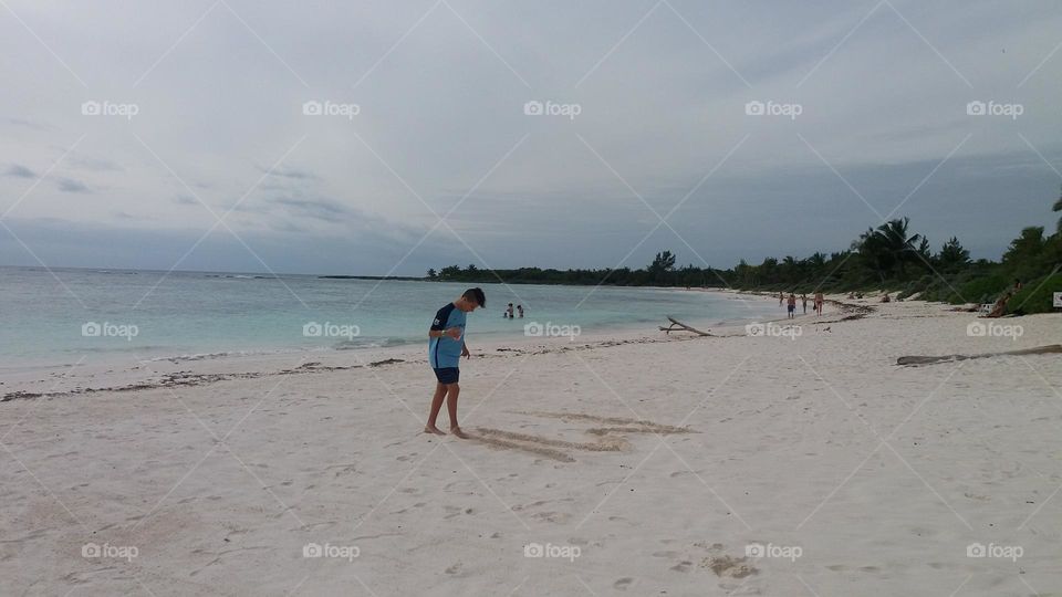 en la playa dibujando en la arena