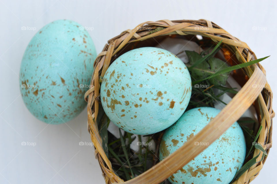 Close-up of painted Robin eggs in a small basket