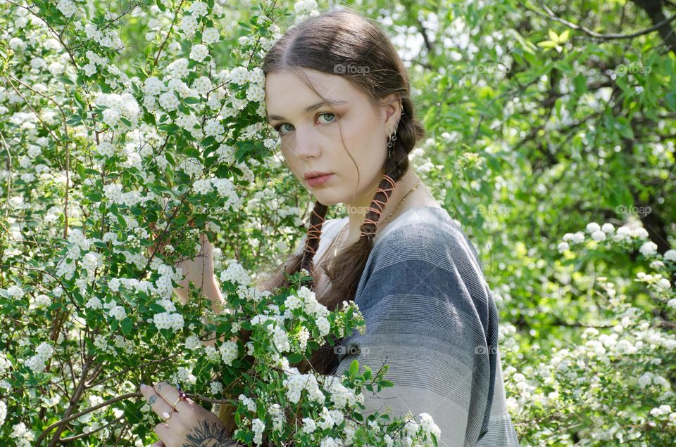 Portrait of Young Girl on Background of Flowers