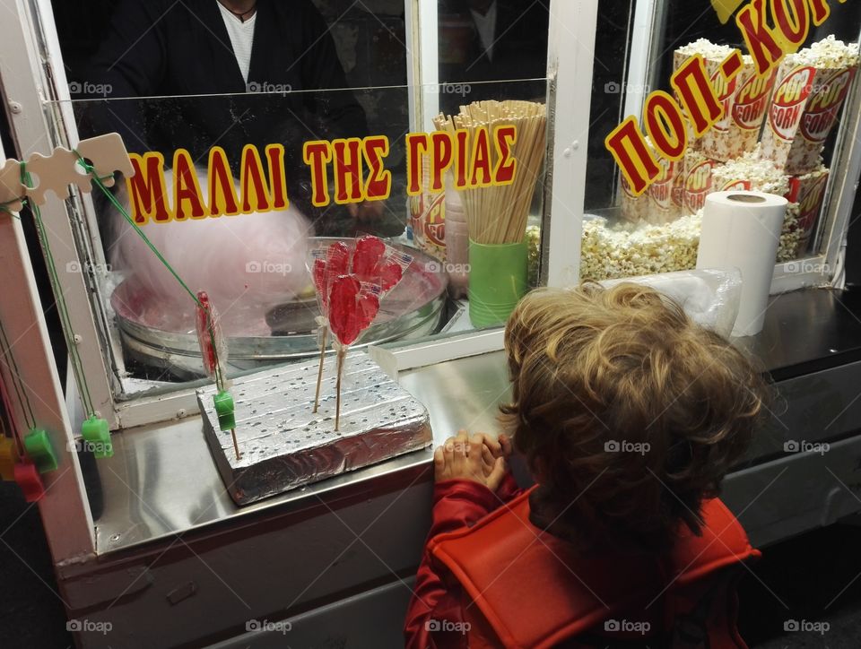 child in costume waiting for cotton candy
