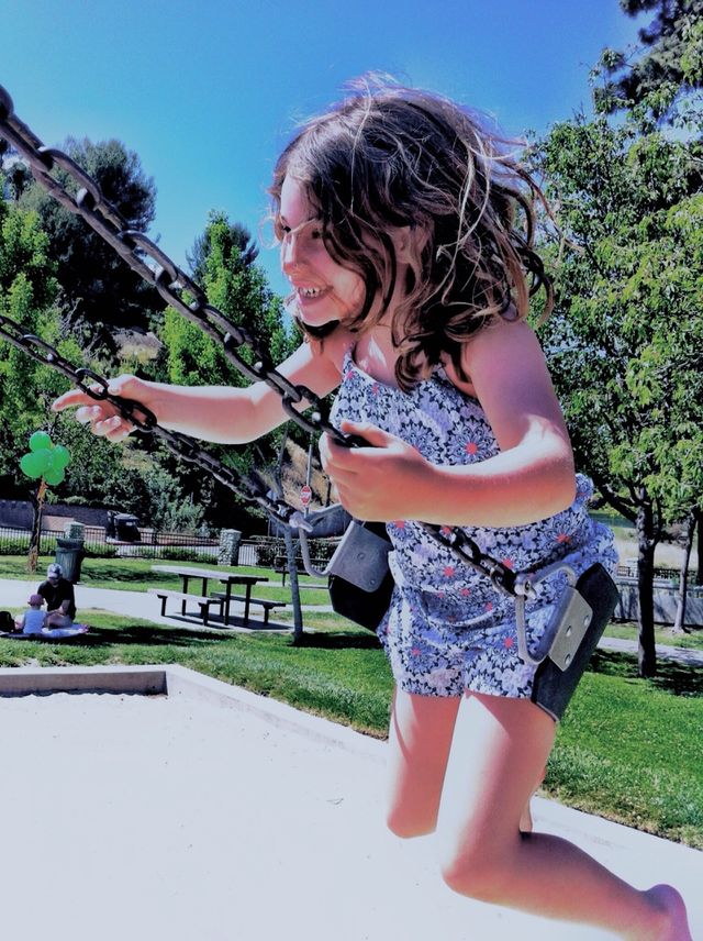 Happy girl on swings 