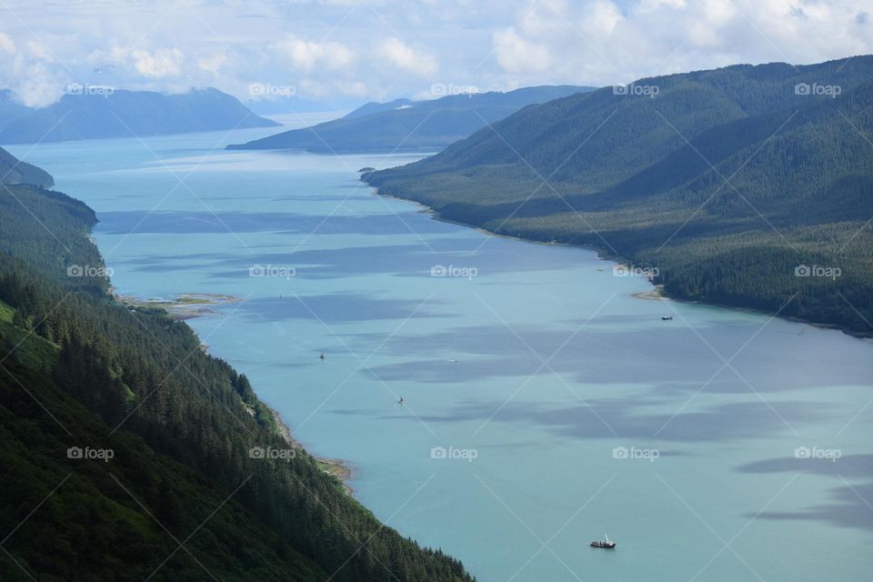 A clear blue fjord stretches for miles near Juneau Alaska and is the primary travel route for tourism and commerce