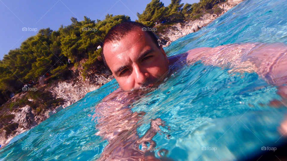 man swimming in the sea surface