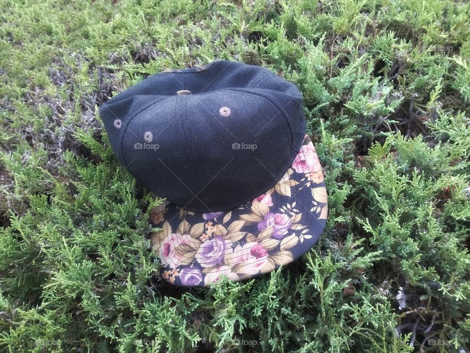 Navy cap with flowers design on a bush.