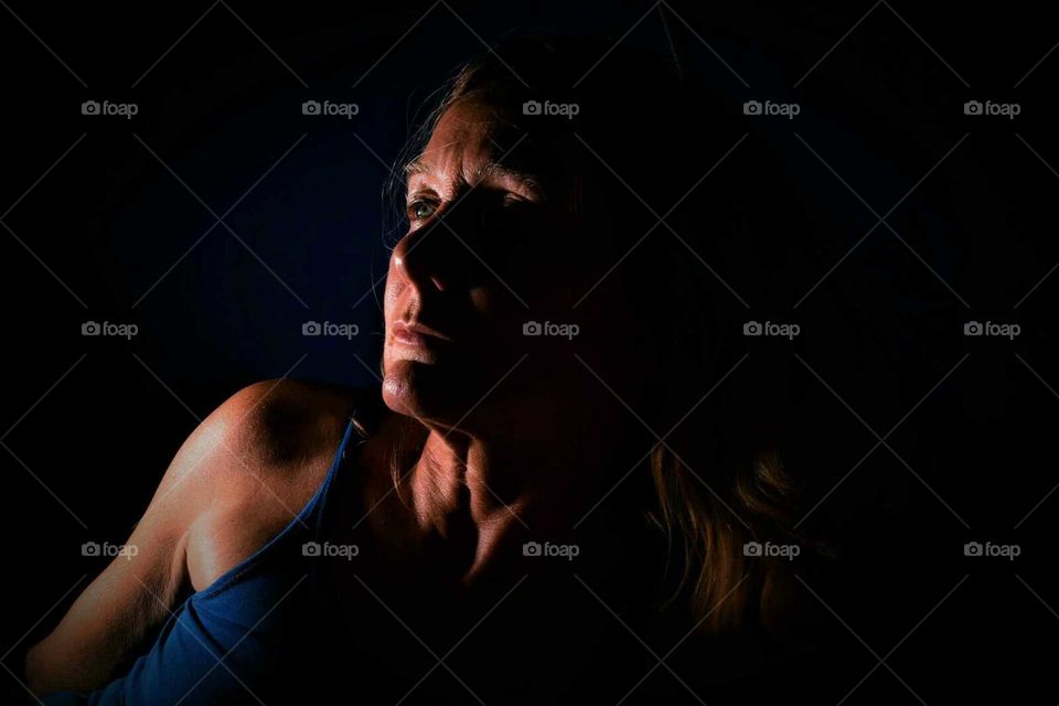 low key color portrait from a woman with black background