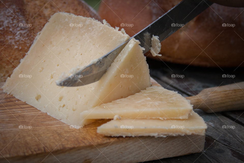 Cutting slices of cheese on the table