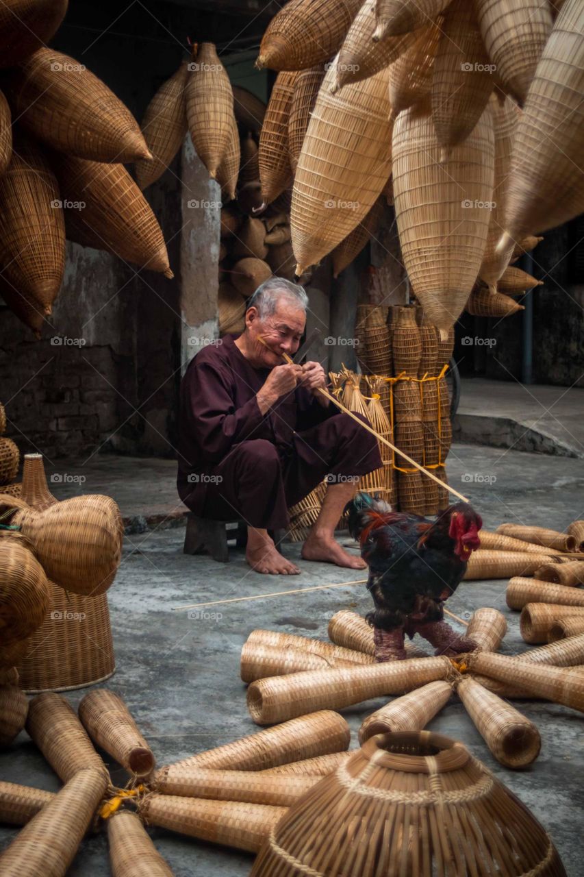 Old man making fishing pots in Vietnam 