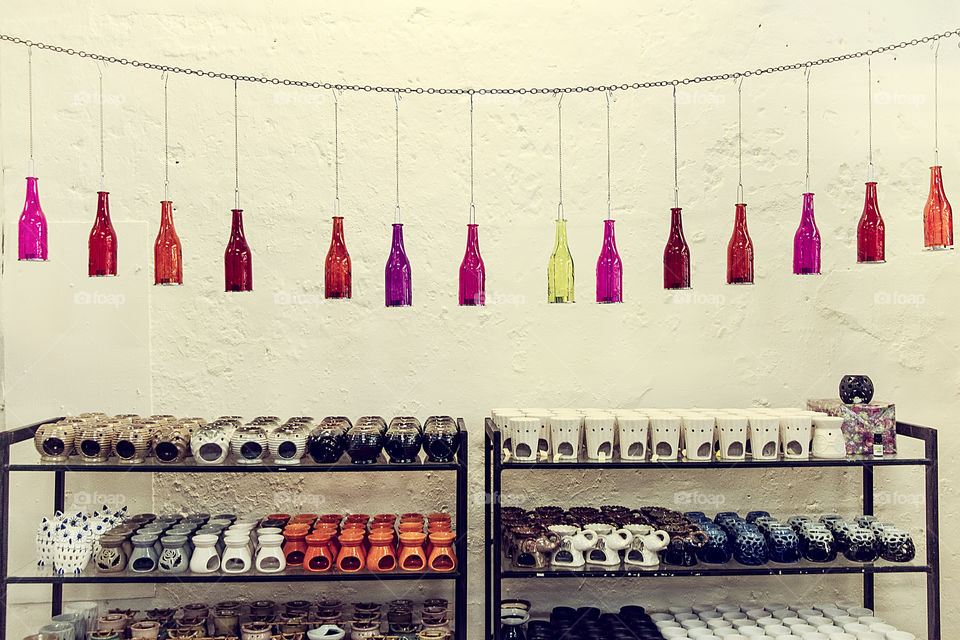 Multi colored bottles hanging above souvenirs