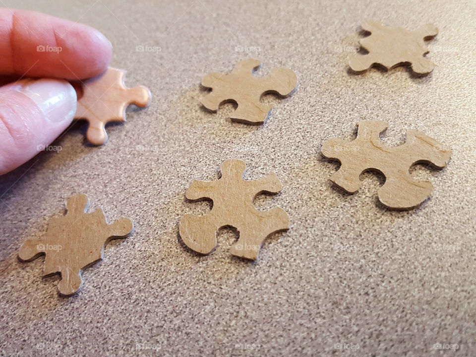 Small group of puzzle pieces with human finger