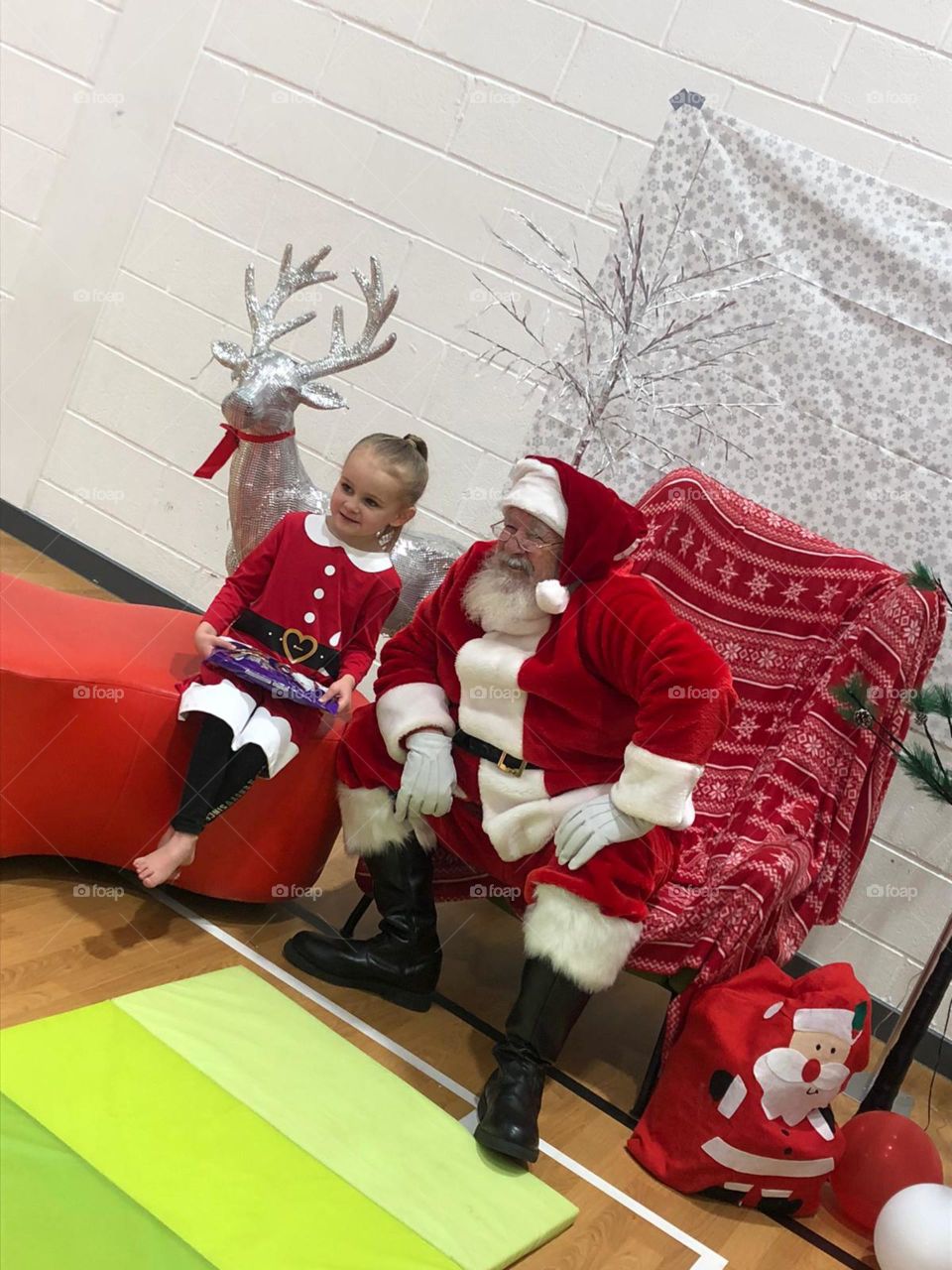 Little girl meets Father Christmas at her Gymnastics club 