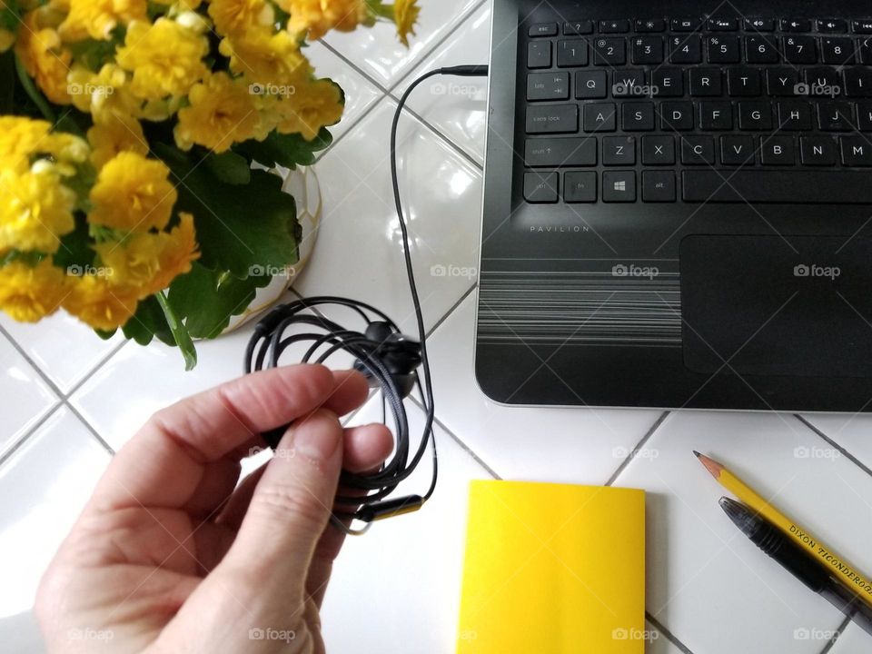 Hand Holding earphones connected to a computer