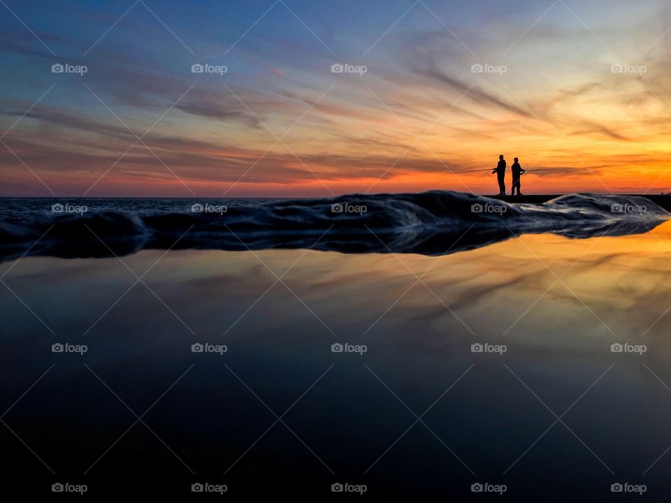 Silhouettes at the sea during sunset. 