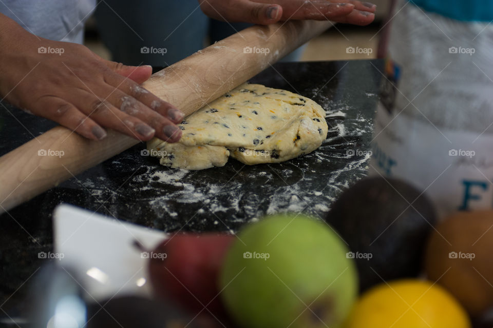 A woman is in the kitchen baking and cooking homemade scones with fruit and fresh herbs