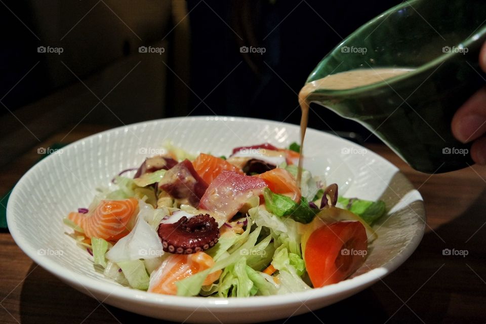 Salad with dressing pouring over