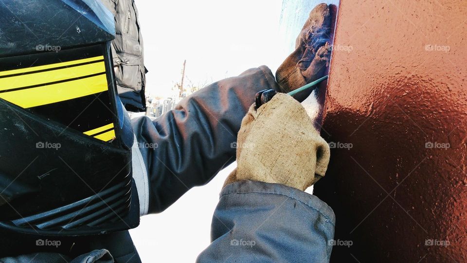 Welder work with metal construction overalls