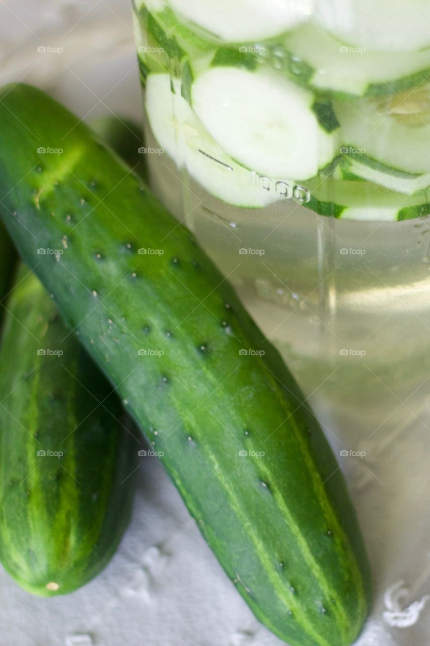 Fruits! - Cucumber-infused water in a half-gallon mason jar with cucumbers on a white dish towel