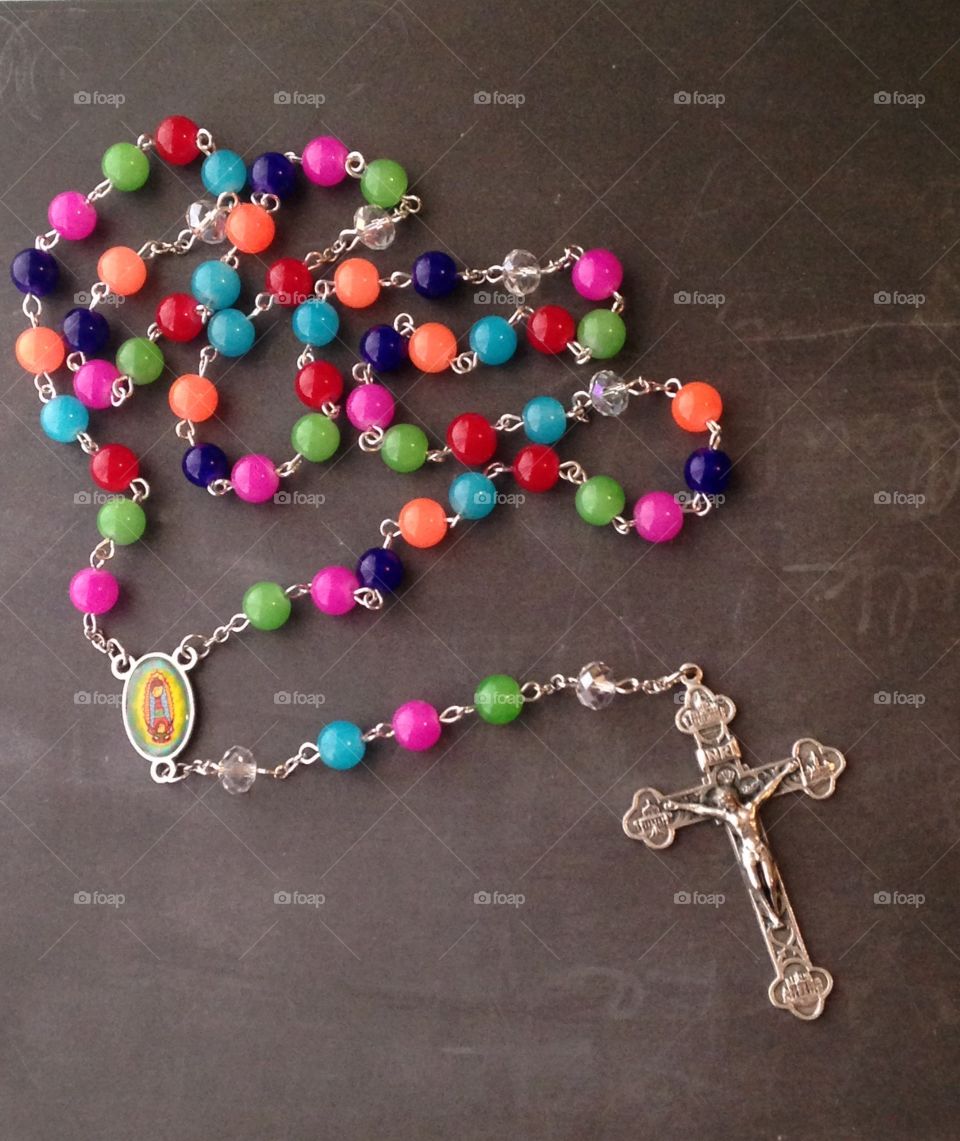 Colorful Rosary. Rosary with different round color beads. Beads are orange, pink, blue, green and bluish purple. 
