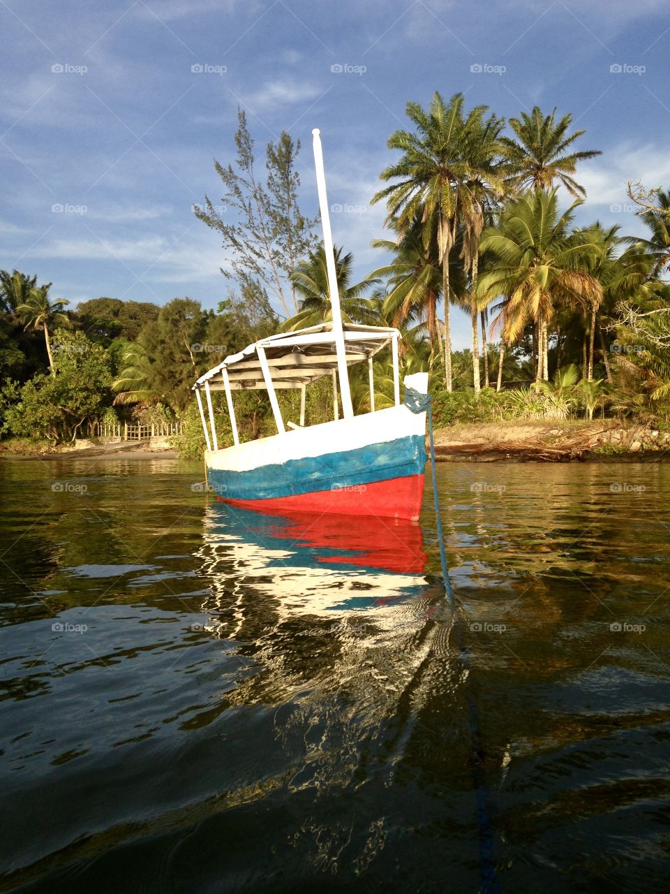 a blue, red and white boat on the beach of Catu, Itaparica, Bahia