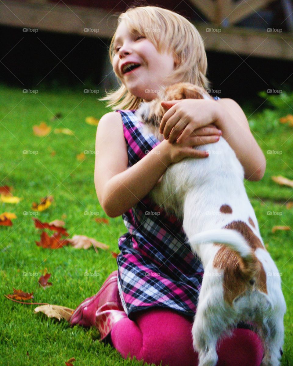 Cute happy girl with puppy at park