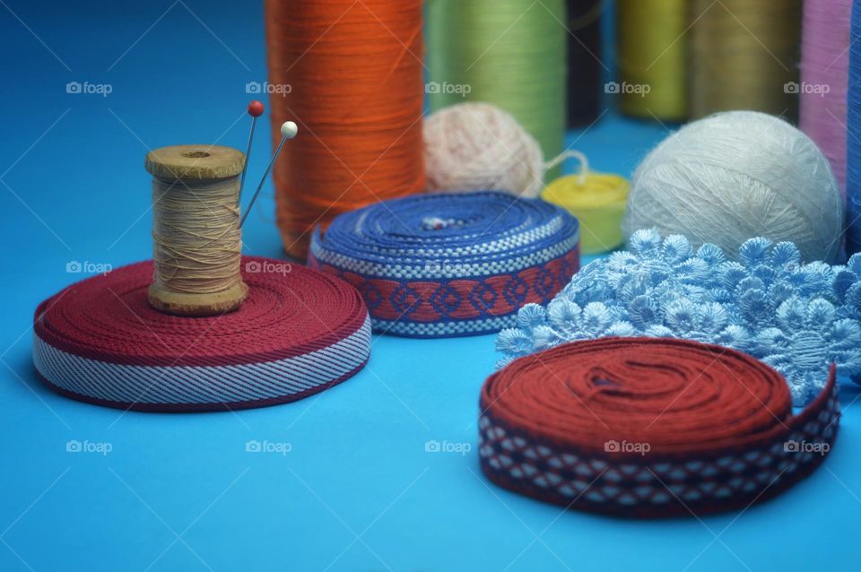 bright photo with sewing thread spools and needles on a blue background. I'll leave it in place for the inscriptions.