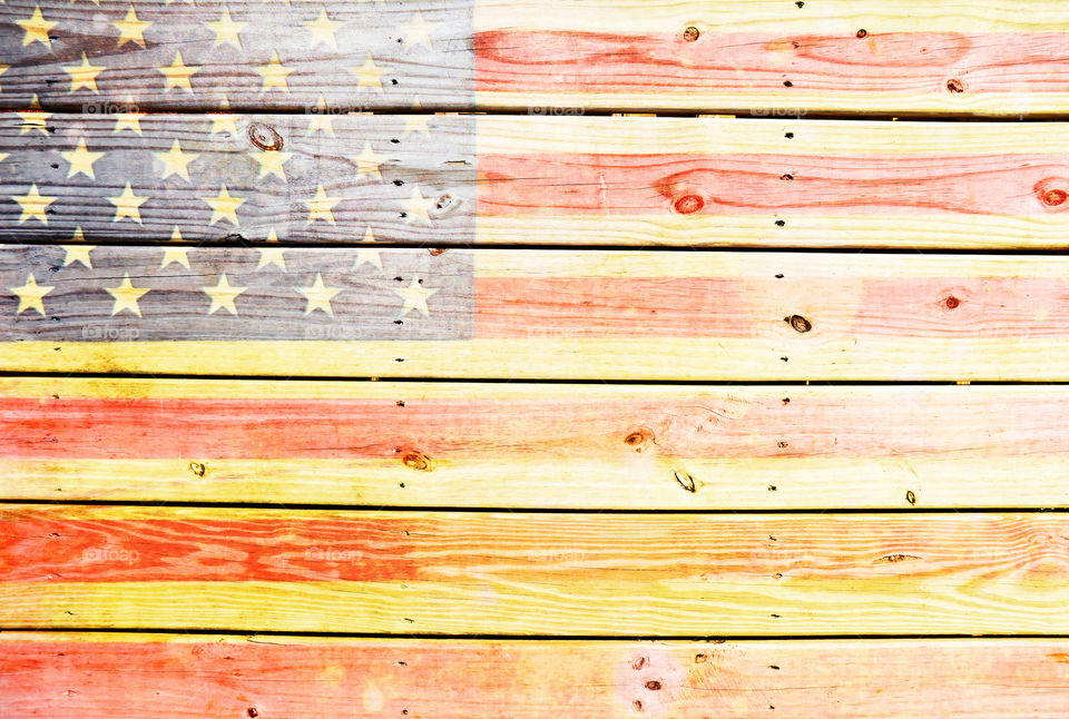 Vintage aged American flag on wooden background.