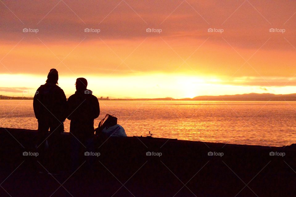 Silhouette of people at beach during sunset