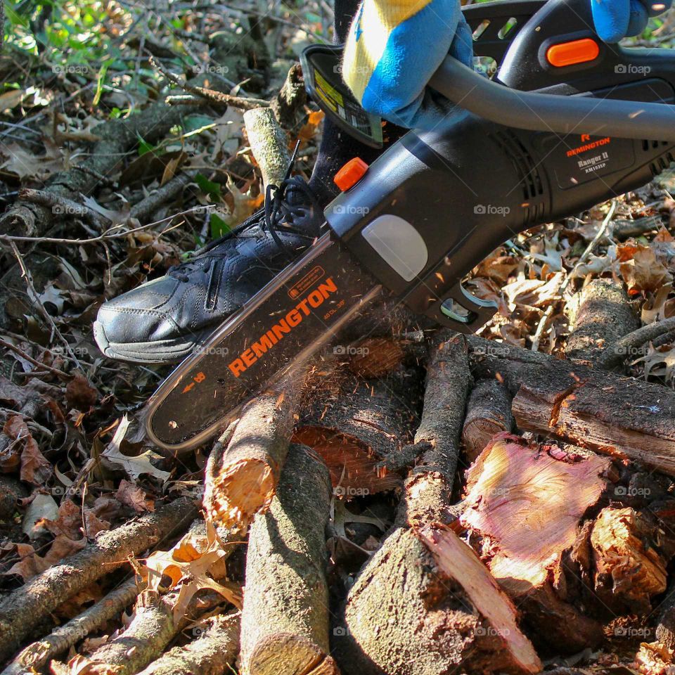 Cutting logs with a Remington electric chainsaw