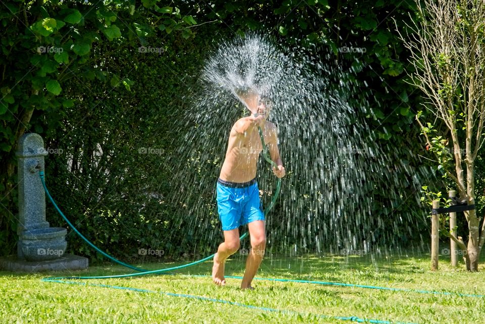 A child splashes water in the garden 
