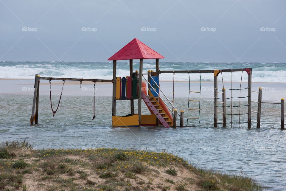Inundated beach playground  . Shot of a destroyed playground on the beach in Tarifa. 