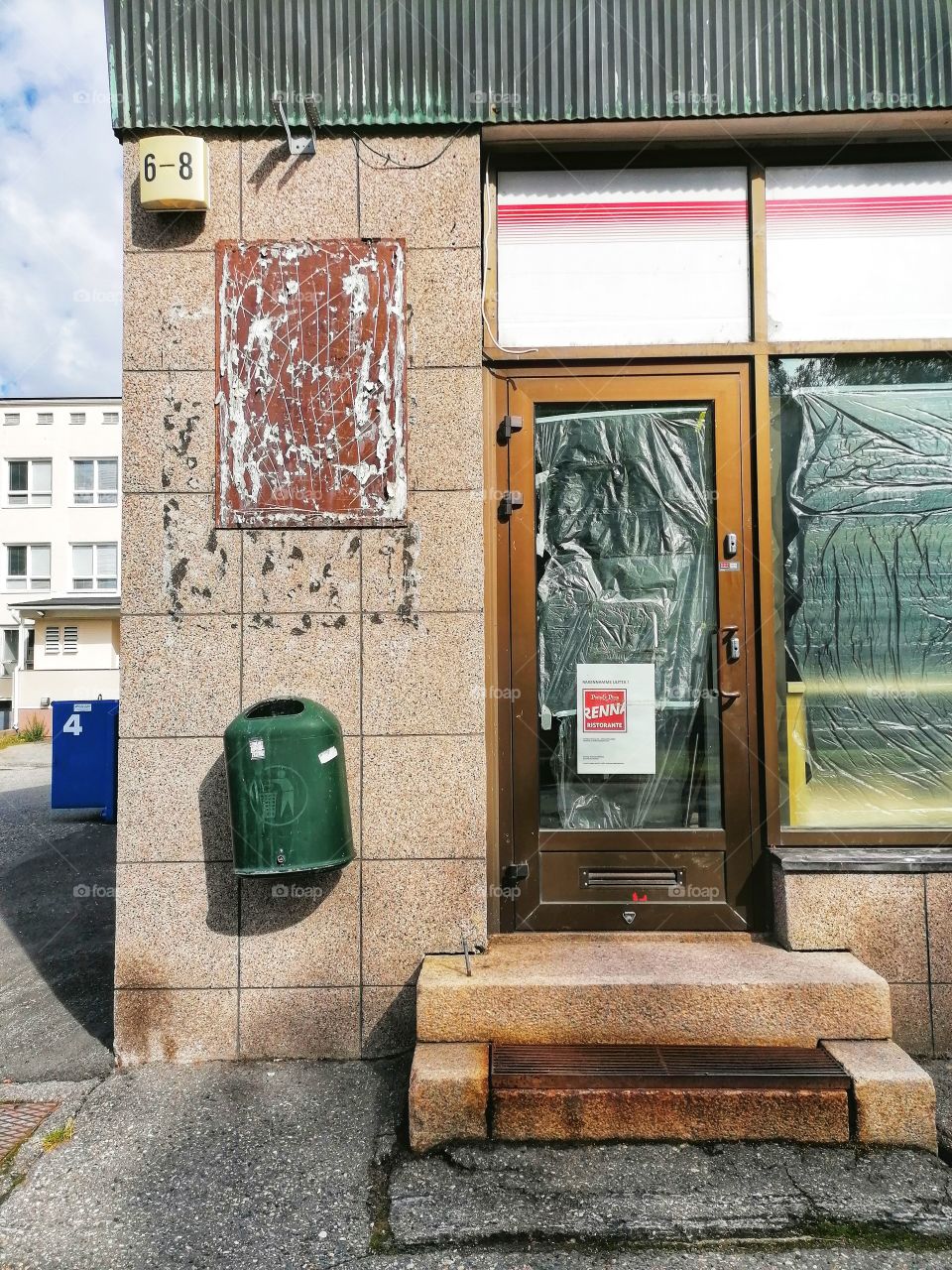 An old dilapidated building in the middle of a town that used to be a shop. No one walks through these doors anymore. Sad.