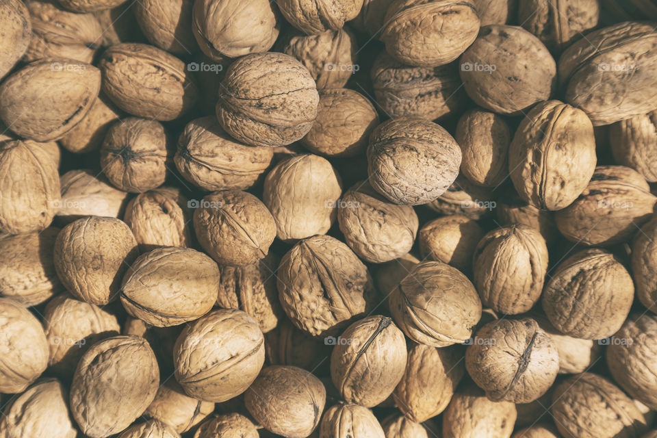 Organic walnuts in their shells, top view flatlay. Filled frame.