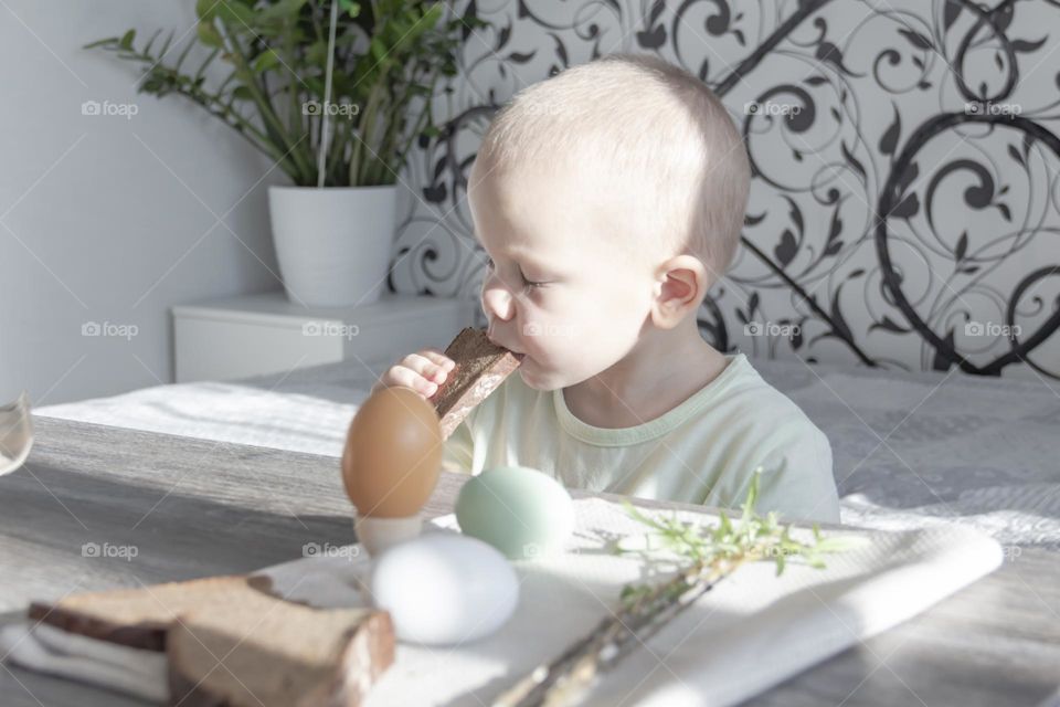 A small, bald man eats bread with his eyes closed and enjoys the taste of food.