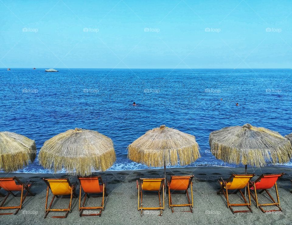 Beach umbrellas and orange deck chairs