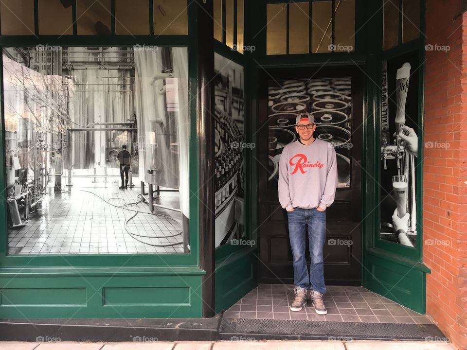 Young man posing in front of well known Portland brewery. 