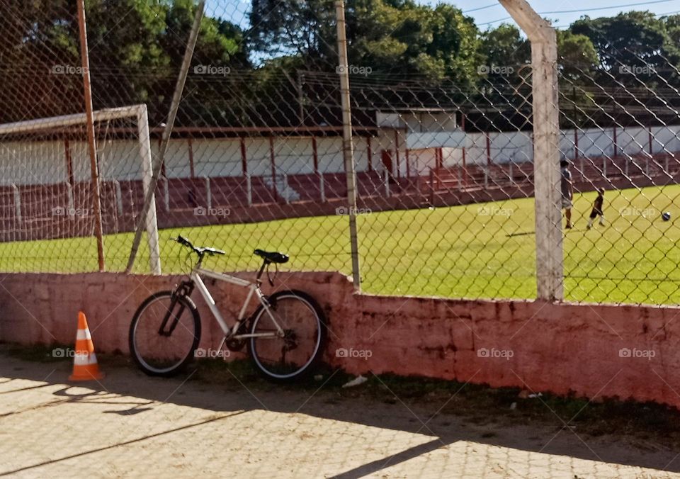 A bycicle by a football field.