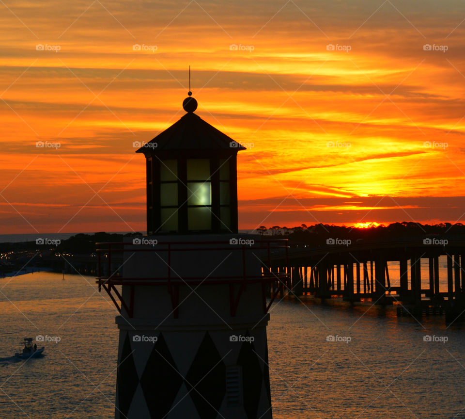 Dramatic sky and silhouette of lighthouse at sunset